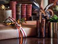 Cadeaux de Noël emballés à côté de plantes et d'ornements sur buffet