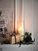 Cadeau de Noël, décoration et bougie allumée sur la cheminée