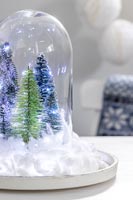 Boule à neige avec faux arbres, guirlandes lumineuses et neige en coton