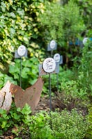 Étiquettes de plantes décoratives et ornements de poulet dans un jardin d'herbes aromatiques