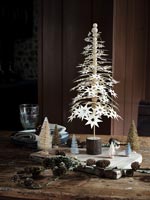 Petit arbre étoilé en papier entouré d'autres arbres miniatures - Affichage de Noël
