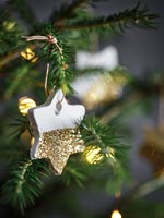 Étoile en céramique blanche et or sur sapin de Noël