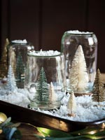 Boules à neige maison utilisant un plateau, de la fausse neige et des arbres de Noël miniatures