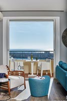 Salon moderne avec vue sur la mer par des portes-fenêtres ouvertes