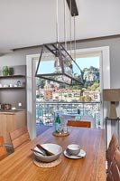 Salle à manger dans un appartement côtier moderne avec vue sur le port à travers les fenêtres