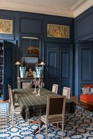 Murs lambrissés peints en bleu foncé dans la salle à manger de style classique