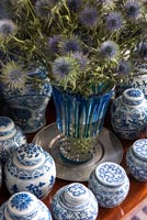 Fleurs dans un vase entouré d'une collection de porcelaine bleue et blanche