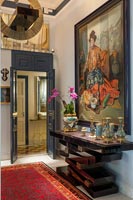 Grande peinture classique et table console inhabituelle dans le couloir