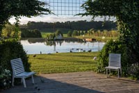 Salon de jardin sur une terrasse avec vue sur le lac au-delà