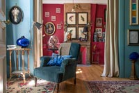 Fauteuil bleu dans un salon de style classique avec des murs peints de couleurs vives