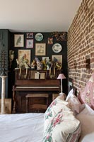 Petit piano recouvert d'ornements dans une chambre éclectique