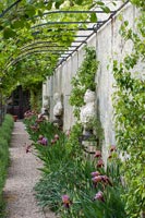 Iris en fleurs et sculptures classiques dans le jardin à la française