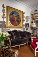 Grande peinture classique au-dessus d'un canapé en velours marron dans un salon éclectique