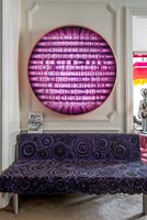 Canapé à motifs violet sous des illustrations colorées