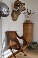 Chaise de moines en bois sous la tête de trophée d'un animal sur le mur