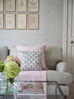 Coussins roses et gris sur canapé dans un salon moderne