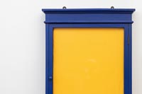 Cadre en bois peint bleu avec panneau de liège recouvert de tissu jaune
