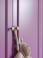 Jouet suspendu à des portes d'armoire peintes en violet