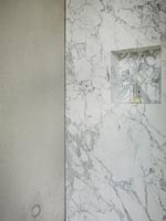 Étagère en alcôve dans le mur de marbre de la salle de bains moderne