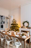 Table à manger en bois posée pour le dîner de Noël dans la salle à manger blanche