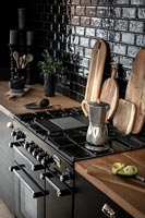 Cafetière sur cuisinière dans une cuisine moderne en bois et noir