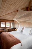 Chambre champêtre avec baldaquin moustiquaire au-dessus du lit