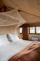 Chambre champêtre avec moustiquaire sur le lit