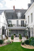 Petit jardin à la française à l'extérieur de la maison classique peint en gris et blanc