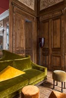 Salon classique avec des meubles en velours et des murs lambrissés