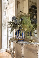 Grand vase de fleurs bleu et blanc sur table console à motifs