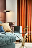 Canapé bleu et rideaux orange dans le salon moderne
