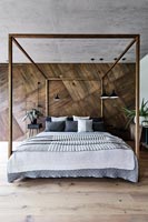 Chambre moderne avec mur en bois et lit à baldaquin
