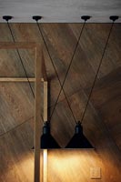 Lampes à suspension en métal noir à côté du mur en bois
