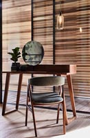 Coiffeuse et chaise en bois noir et marron à côté de la fenêtre