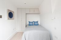 Chambre moderne avec placard intégré et espace de rangement autour du lit