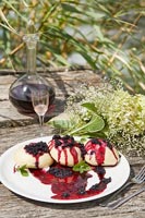 Vin et gâteaux aux fruits des bois sur table de jardin
