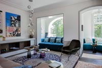 Salon moderne avec des canapés dans des alcôves de fenêtre