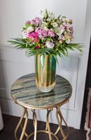 Vase de fleurs sur petite table d'appoint avec plateau en marbre