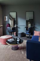 Salon moderne avec paire de miroirs et chaises assorties à une extrémité
