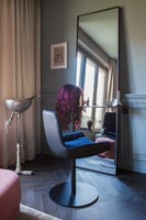 Chaise pivotante à côté du miroir dans un salon moderne éclectique