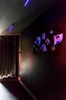 Éclairage au néon lumineux et images dans le couloir peint en noir