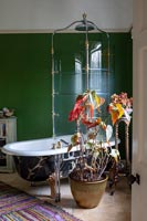 Paroi de douche vintage sur baignoire sur pied dans salle de bain éclectique