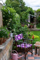 Chaise de jardin avec tissu à motifs violet et arrosoir rose