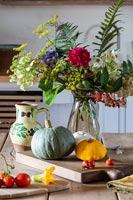 Détail de l'arrangement floral sur table de pays avec des légumes récoltés