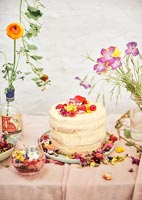 Gâteau de célébration recouvert de fruits et de fleurs comestibles