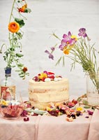 Gâteau sur table de jardin couverte de fleurs pour pique-nique de célébration