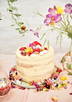 Gâteau sur table de jardin couverte de fleurs pour pique-nique de célébration