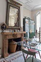 Cheminée en bois sculpté et grand miroir inhabituel dans une salle à manger éclectique