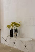 Vases noirs de fleurs sur table blanche