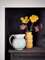 Fleurs dans un vase à côté de la cruche avec fond noir